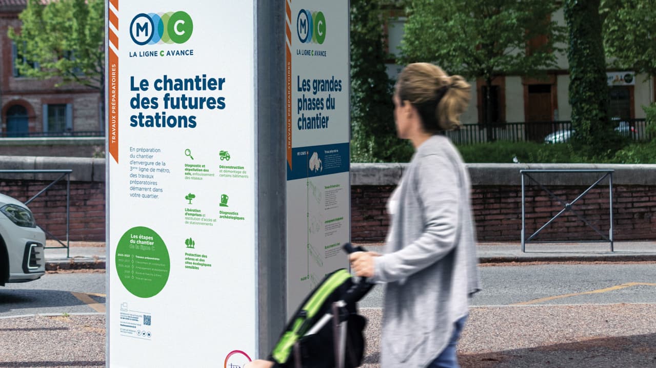 Une dame avec une poussette devant le tripode